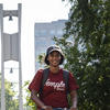 Student walking on Temple's campus with bell tower in background